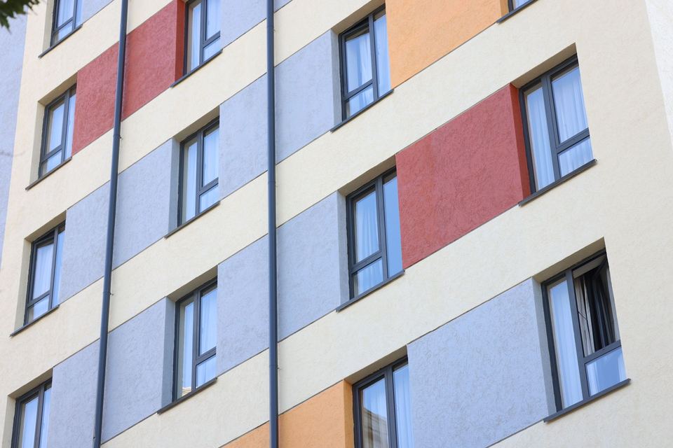 Façade d'immeuble habillée de panneaux clairs et colorés après isolation
